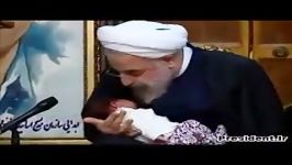 اذان گفتن روحانی در گوش نوه شهید علی محمدی