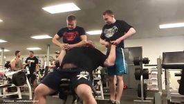 Eddie Hall shows off his strength by bench pressing two men