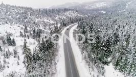فوتیج هوایی ماشین روی جاده کوهستانی در زمستان